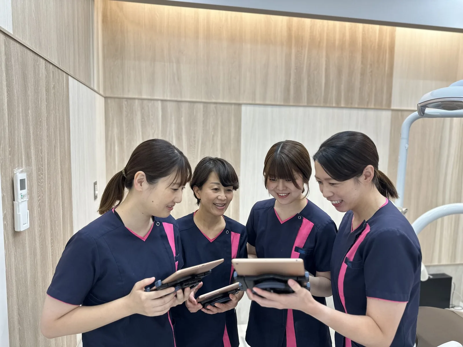 タブレットを見ながら話し合うスタッフ